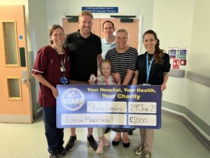 A photo of Steve and his niece, presenting his fundraising cheque to staff at Salisbury hospital.